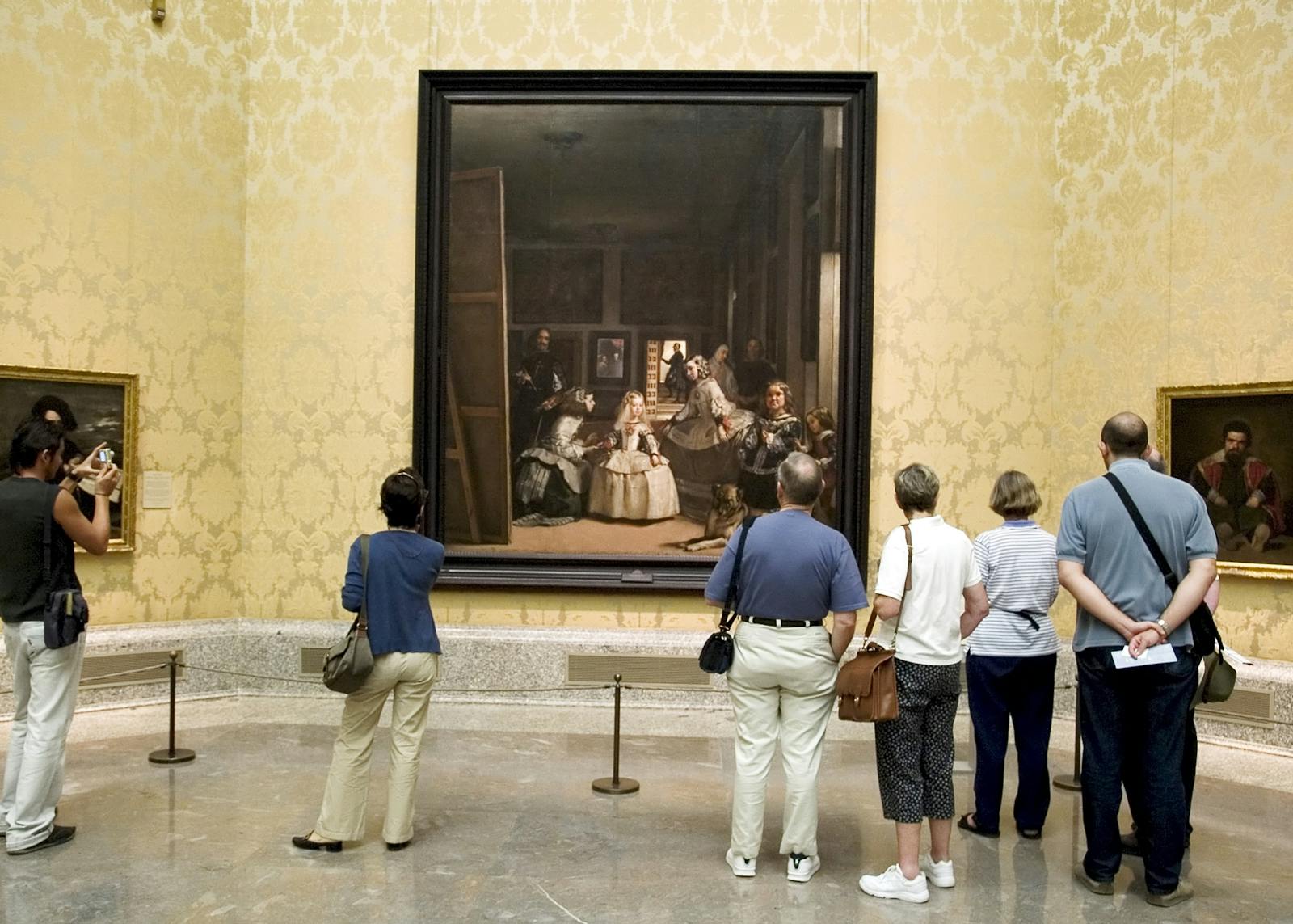 Visitatori che ammirano un grande dipinto al Museo del Prado